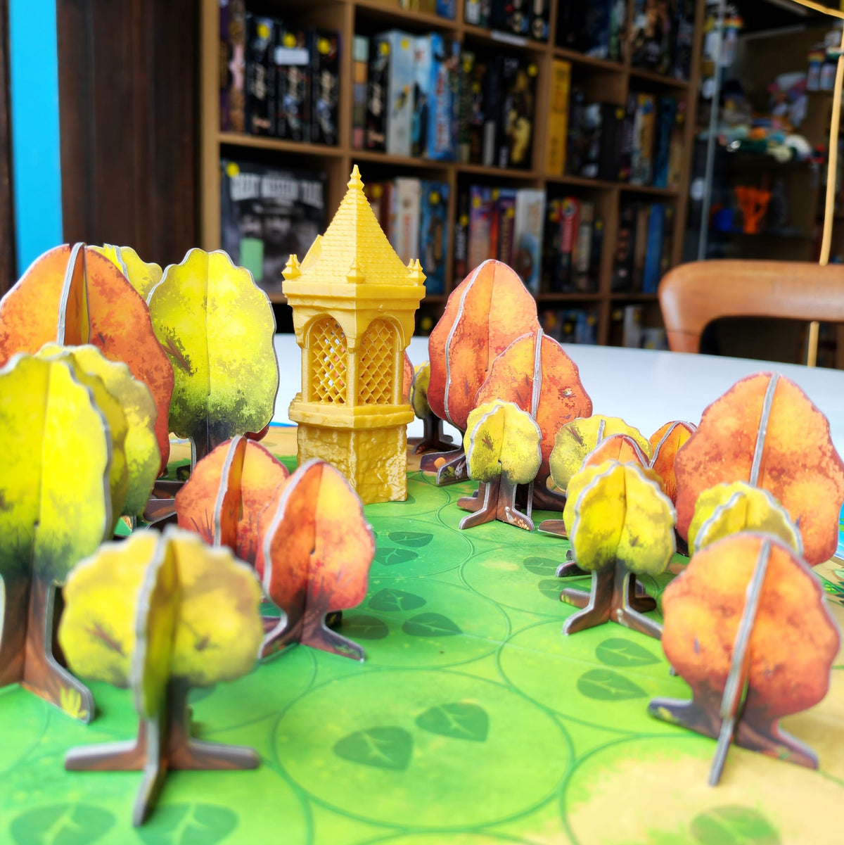 Painted miniature trees and a tower on a gaming table