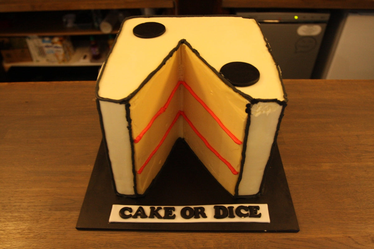 A cake shaped like a dice with a slice cut out, labelled Cake or Dice