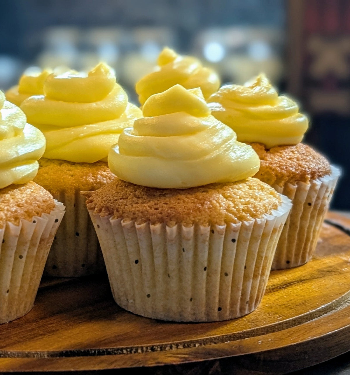 Cupcakes with yellow frosting on a wooden board